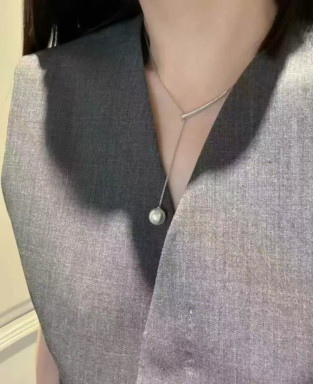 简约中的奢华：灰色上衣与独特项链的魅力组合